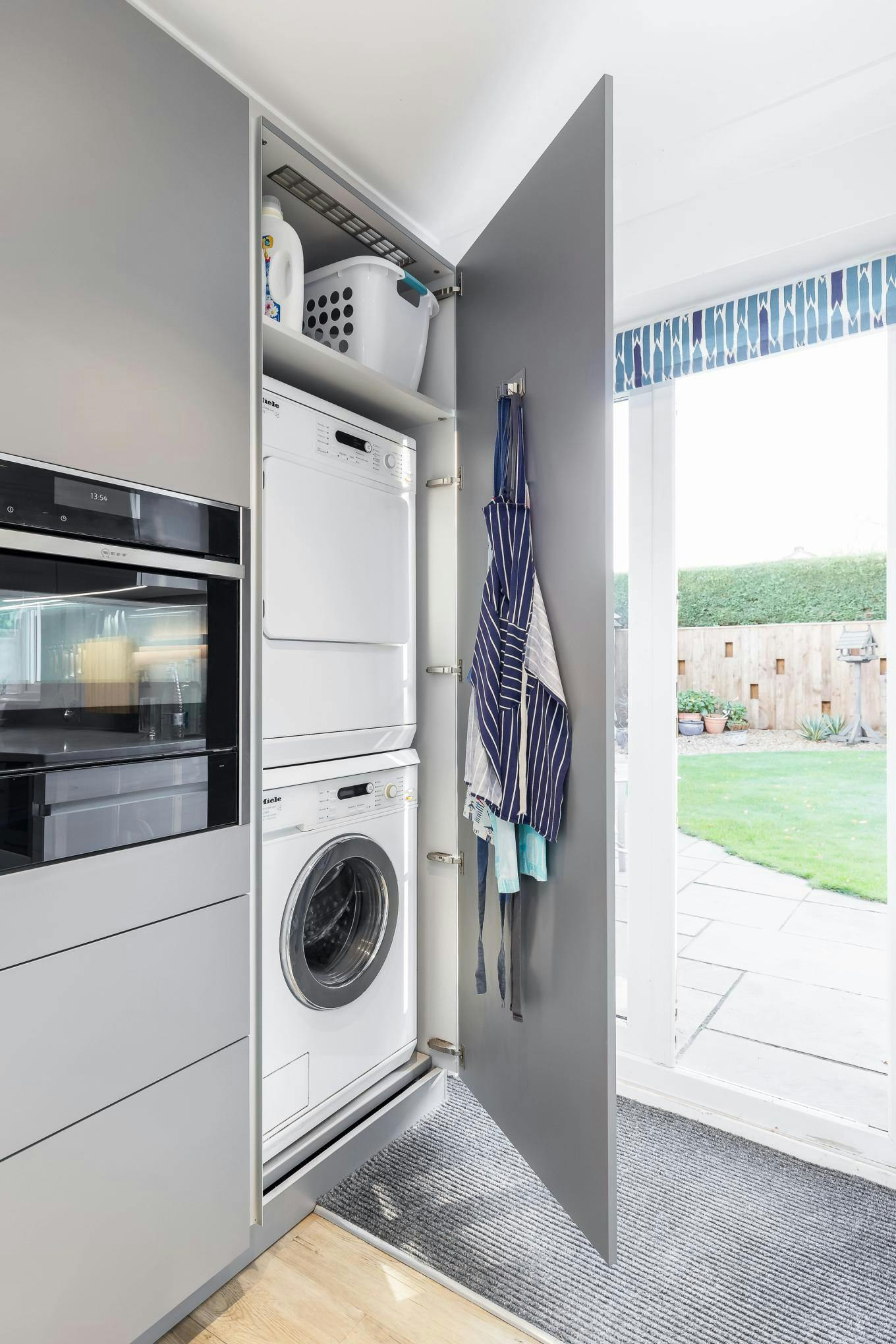 Stacked washing machine and tumble dryer concealed behind door